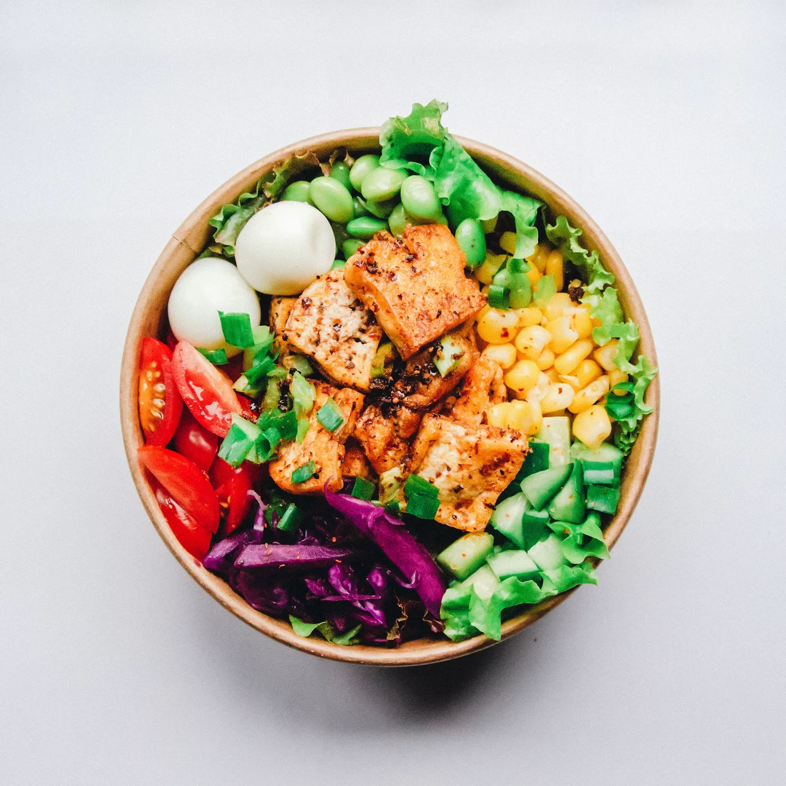 Colorful bowls of roasted vegetables, greens and grains arranged on a table